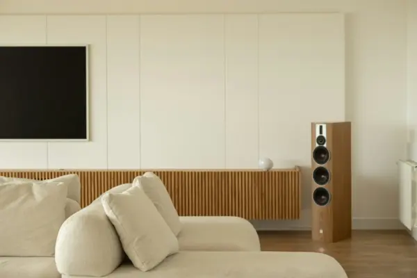Altavoz de suelo de columna en madera junto al televisor en un salón moderno