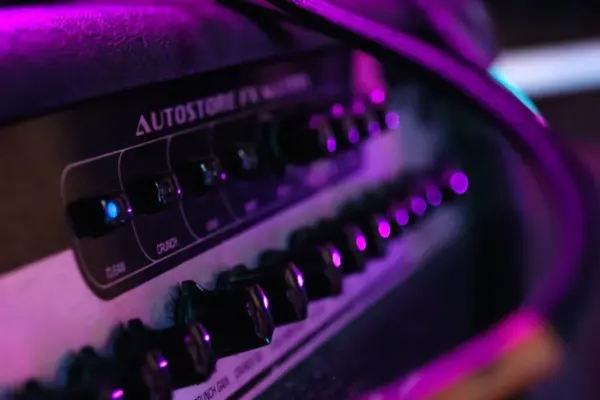 Panel de mandos y canales de un amplificador de guitarra con luz de escenario