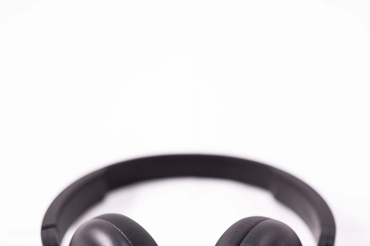 Auriculares de diadema negros cerrados sobre fondo blanco