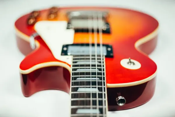 Primer plano del cuerpo de una guitarra electrica con sus pastillas y cuerdas