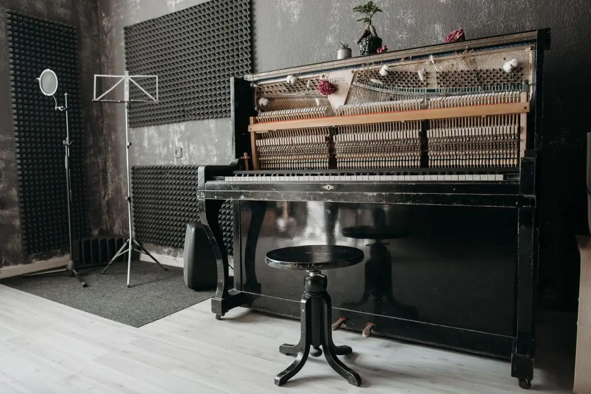 Sala tratada con paneles acústicos en las paredes y un piano