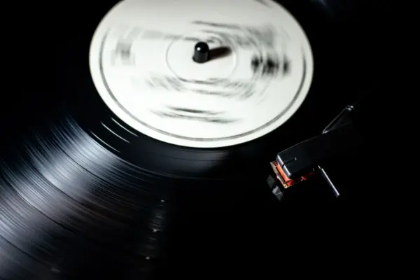 Aguja de un tocadiscos leyendo un vinilo negro en movimiento