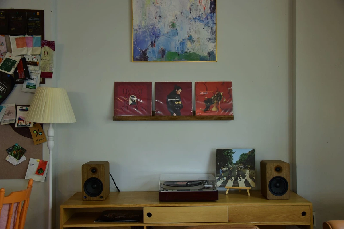 Tocadiscos con dos altavoces de estantería sobre un mueble en un salón